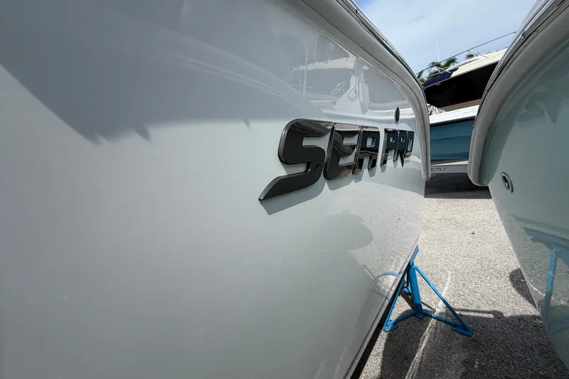 Slide: The Image of 2027 Sea Pro 262 DLX boat side view with logo, displayed on a stand. - 25