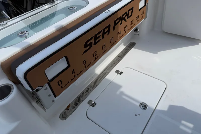 Slide: The Image of 2027 Sea Pro 262 DLX boat deck with integrated measuring board and storage hatch. - 14