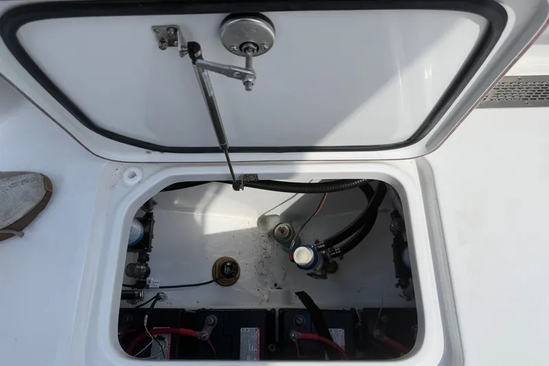 Slide: The Image of Open hatch of a 2027 Sea Pro 262 DLX boat showing internal components. - 35