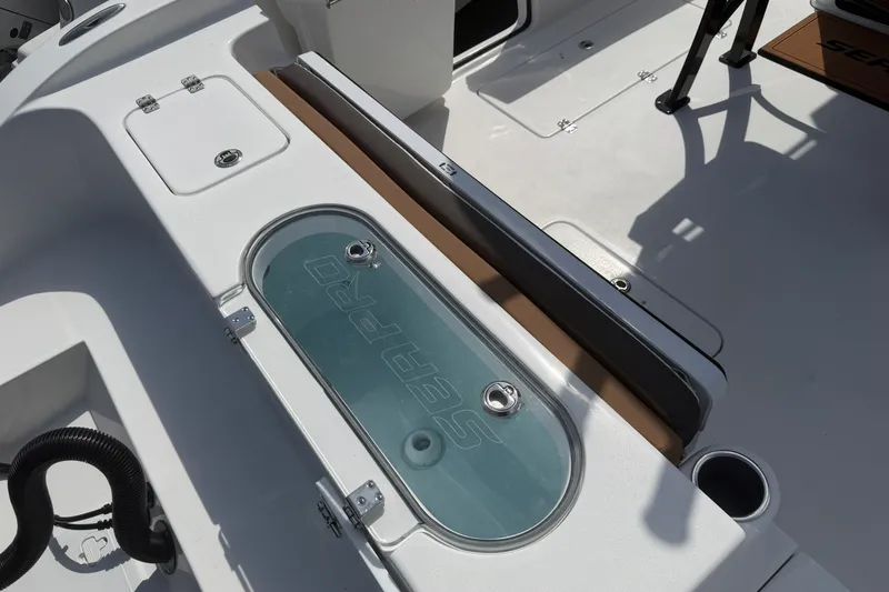 Slide: The Image of 2027 Sea Pro 262 DLX boat interior with livewell and seating area. - 21