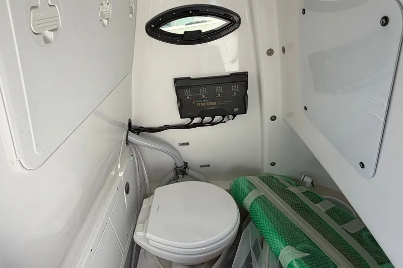Slide: The Image of Interior of 2027 Sea Pro 262 DLX boat featuring compact marine toilet setup. - 47