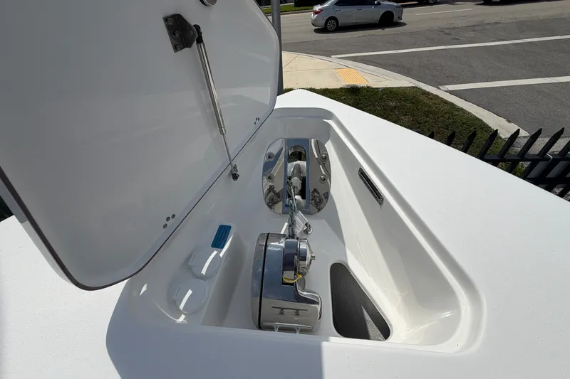 Slide: The Image of Anchor compartment of 2027 Sea Pro 262 DLX boat, open lid, street view background. - 45