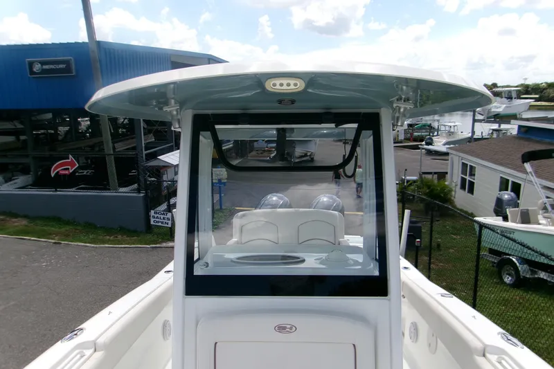 Slide: The Image of 2020 Sea Hunt Gamefish 25 boat at a marina, showcasing helm and seating area. - 19