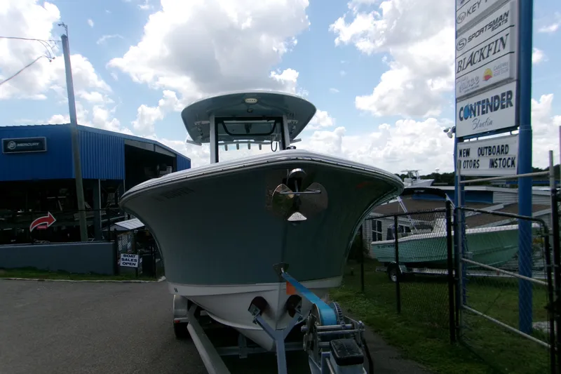 Slide: The Image of 2020 Sea Hunt Gamefish 25 boat on trailer at dealership, under cloudy sky. - 15