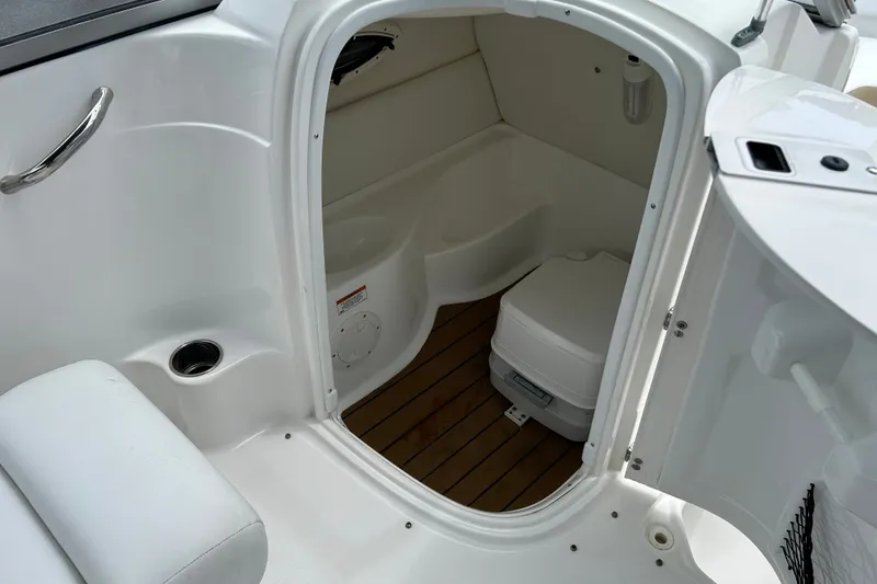 Slide: The Image of 2013 SouthWind 212 SD boat interior with compact marine toilet and wooden flooring. - 16