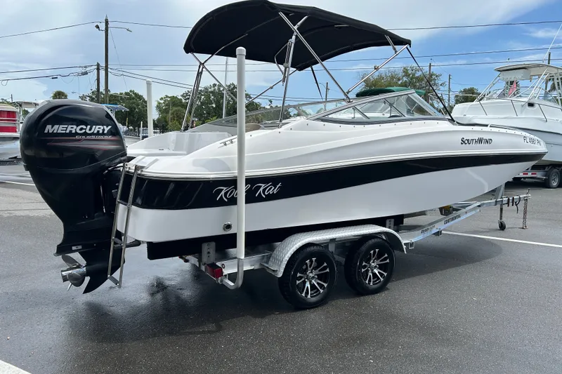 Slide: The Image of 2013 SouthWind 212 SD boat on trailer with Mercury outboard motor, parked outdoors. - 2