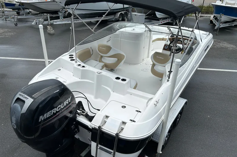 Slide: The Image of 2013 SouthWind 212 SD boat with Mercury engine, featuring spacious seating and canopy. - 7