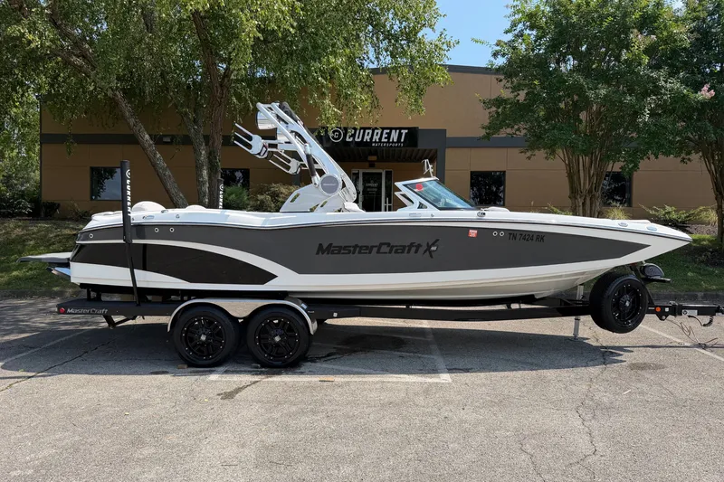 The Image of 2018 MasterCraft X46 boat on trailer, parked outdoors near a building. - 0
