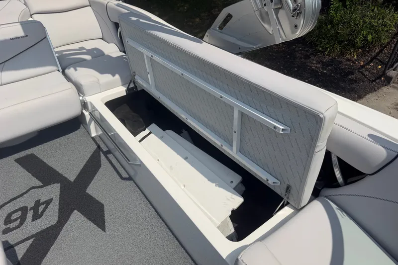 Slide: The Image of 2018 MasterCraft X46 boat interior with open storage compartment and seating. - 10