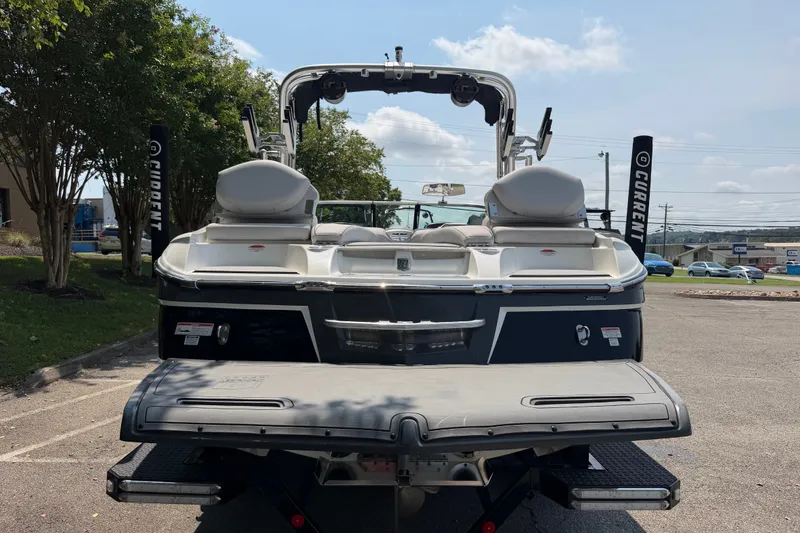 Slide: The Image of 2018 MasterCraft X46 boat rear view in a parking lot, showcasing swim platform and seating. - 4
