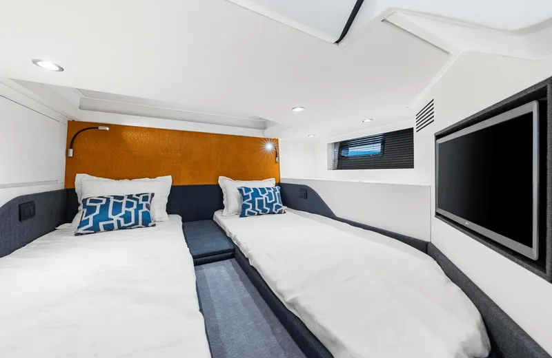 Slide: The Image of The 2025 Azimut Verve 48 cabin features two single beds, modern lighting, and a flat-screen TV. - 9