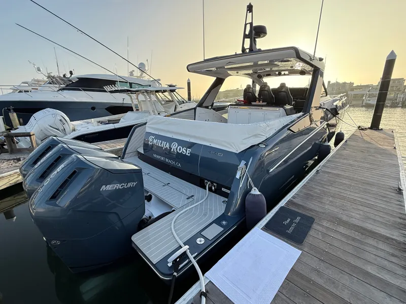 Slide: The Image of A luxurious 2025 Azimut Verve 48 yacht docked. It features a sleek blue hull and powerful Mercury engines. - 2