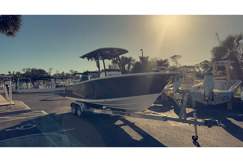 Slide: The Image of 2023 Sportsman Heritage 241 Center Console boat on trailer in sunny marina. - 1
