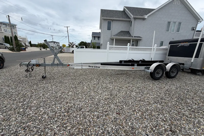 Slide: The Image of Trailer for 2019 Sea Hunt Gamefish 25 on gravel driveway, residential background. - 35
