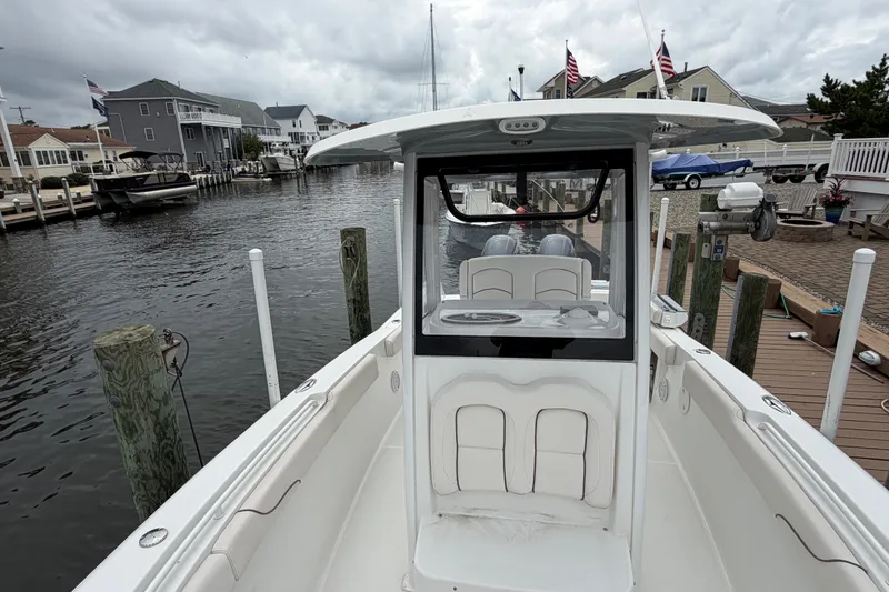 Slide: The Image of 2019 Sea Hunt Gamefish 25 boat docked in a residential marina setting. - 28