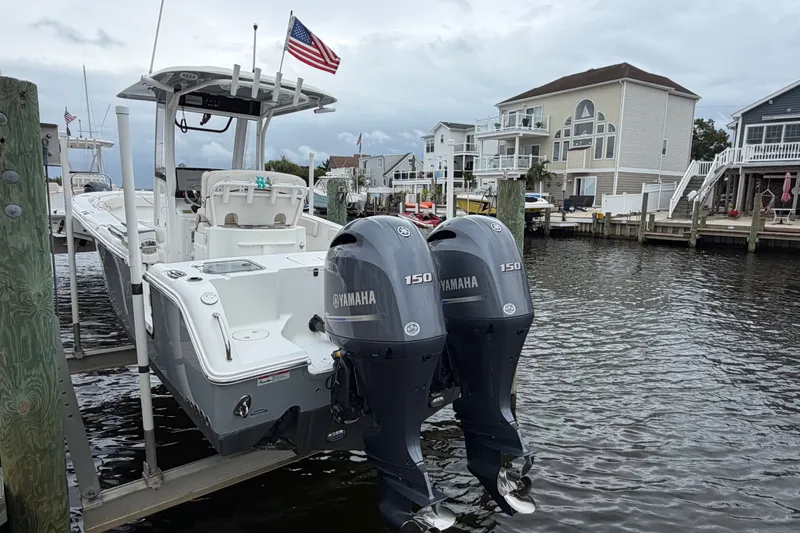 Slide: The Image of 2019 Sea Hunt Gamefish 25 boat with twin Yamaha engines docked by waterfront homes. - 6