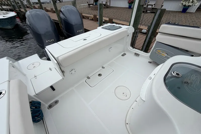 Slide: The Image of 2019 Sea Hunt Gamefish 25 boat interior with twin 150 engines, docked at marina. - 11