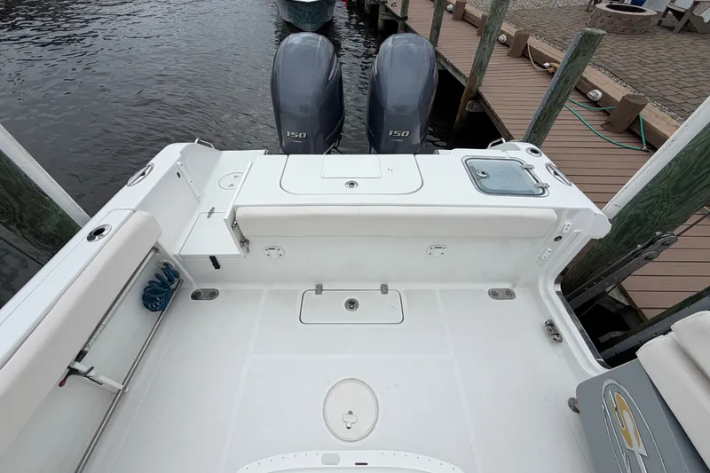 Slide: The Image of 2019 Sea Hunt Gamefish 25 boat with dual outboard motors docked by wooden pier. - 9