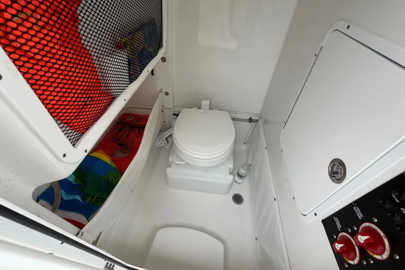 Slide: The Image of 2019 Sea Hunt Gamefish 25 boat interior with portable toilet and storage compartments. - 31