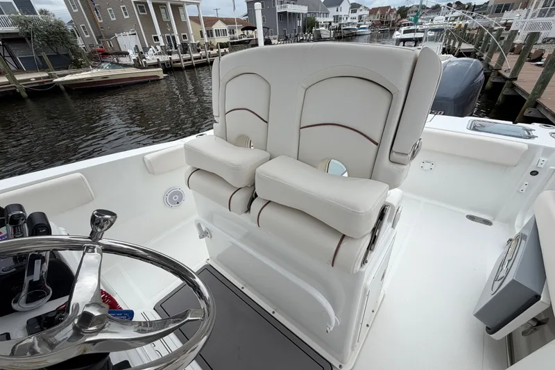 Slide: The Image of 2019 Sea Hunt Gamefish 25 boat interior with dual helm seats and steering wheel. - 16