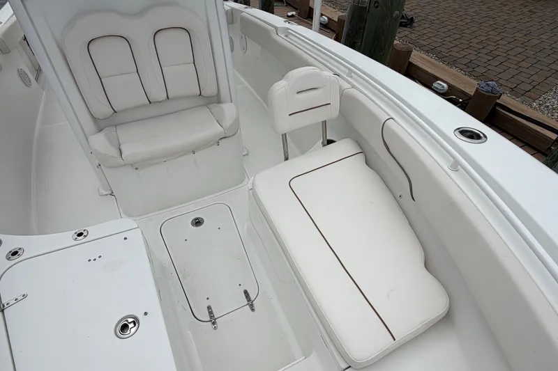 Slide: The Image of 2019 Sea Hunt Gamefish 25 boat interior with white cushioned seating and storage compartments. - 30