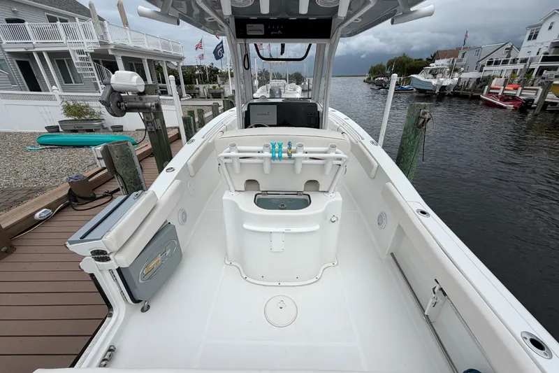 Slide: The Image of 2019 Sea Hunt Gamefish 25 boat docked in a marina, showcasing spacious deck layout. - 14