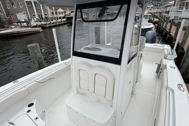 Slide: The Image of 2019 Sea Hunt Gamefish 25 boat docked, showcasing spacious deck and seating area. - 29