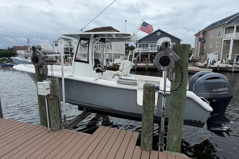 Slide: The Image of 2019 Sea Hunt Gamefish 25 boat docked with Yamaha engine, marina background. - 5
