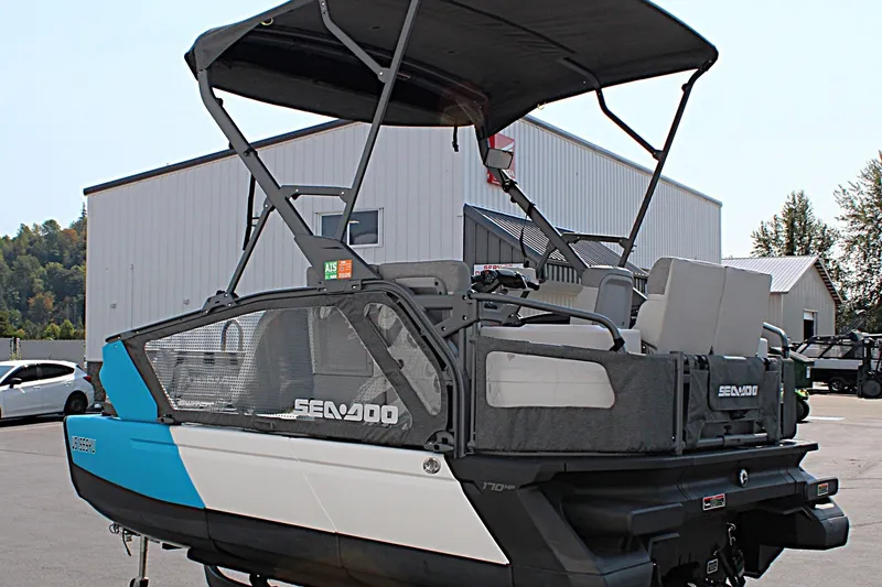 Slide: The Image of 2023 Sea-Doo Switch Sport Compact pontoon boat with canopy, parked outdoors. - 8