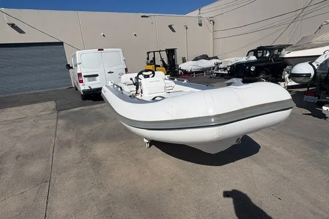 Slide: The Image of 2018 Williams Jet Tenders Sportjet 395 in a storage facility, surrounded by vehicles. - 1