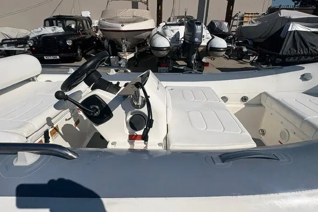 Slide: The Image of 2018 Williams Jet Tenders Sportjet 395, white interior, parked among various boats and vehicles. - 6