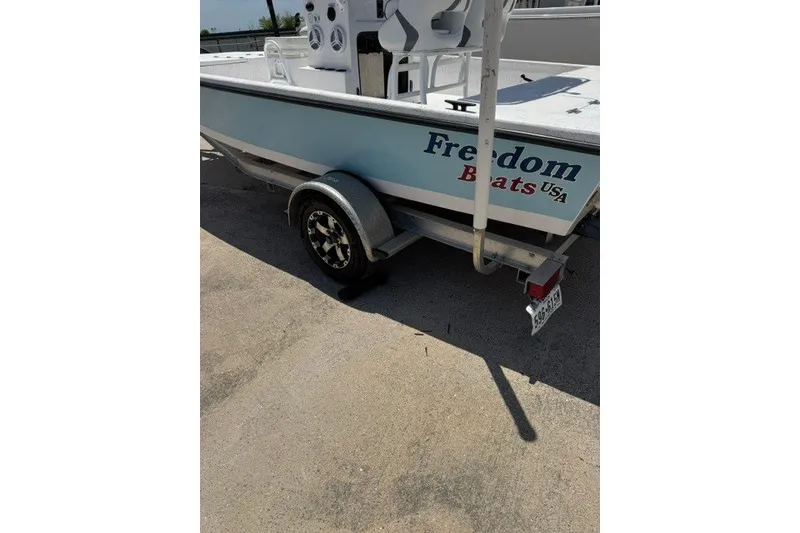 Slide: The Image of 2019 Freedom Boats 18' Patriot on trailer, showcasing sleek design and branding. - 17