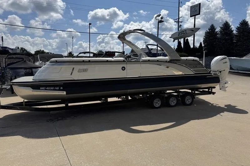 Slide: The Image of 2024 Bennington 30 QXFBAX2 pontoon boat on trailer under a cloudy sky. - 3