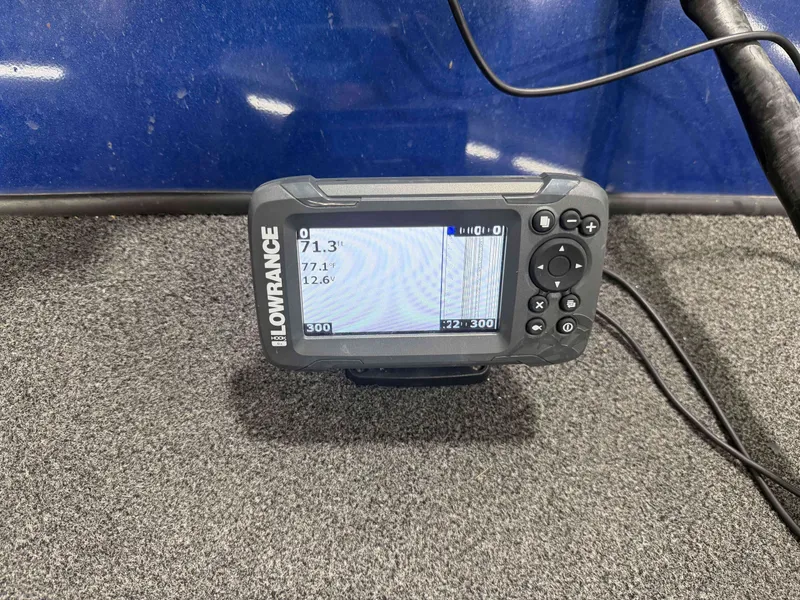 Slide: The Image of A Lowrance fish finder is mounted on a gray carpeted surface. - 16