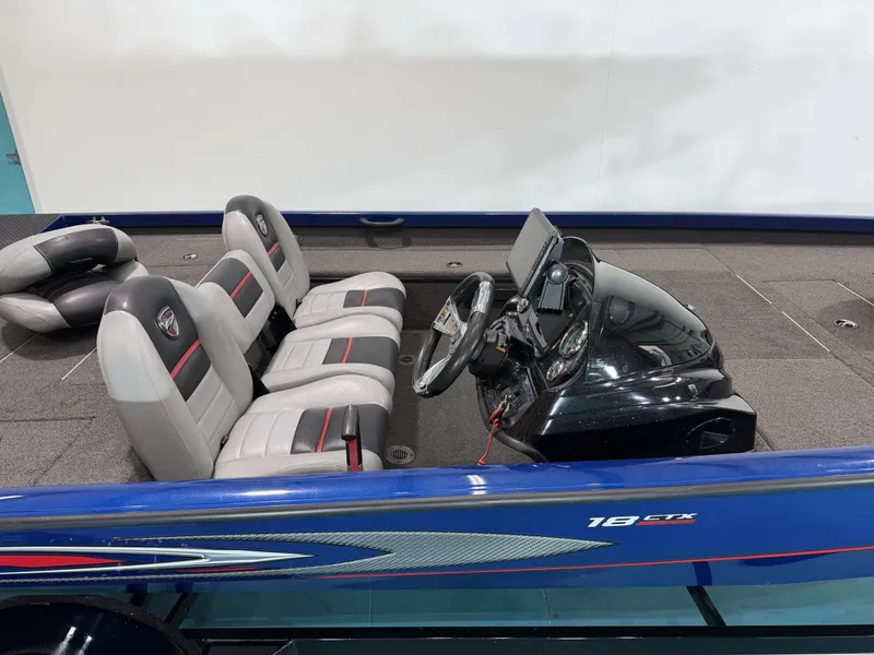 Slide: The Image of The image shows a 2017 Triton 18CTX boat with gray and red seats and a modern helm. - 22