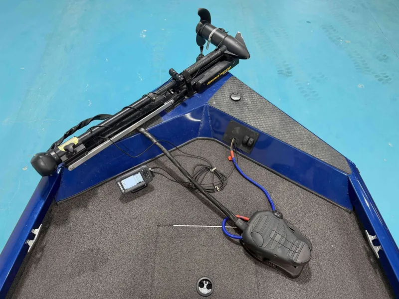 Slide: The Image of The image shows the bow deck of a blue Triton 18CTX boat with a trolling motor. - 14