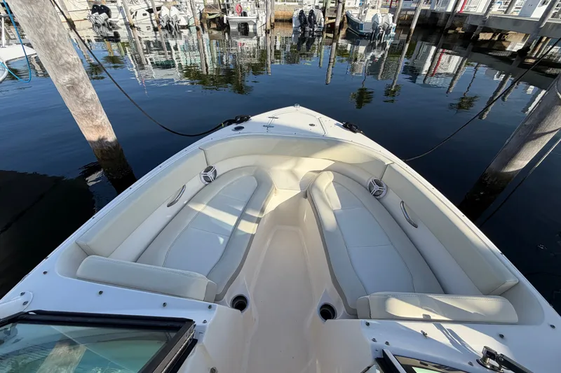 Slide: The Image of 2013 Pursuit DC 265 Dual Console boat docked, featuring spacious seating and sleek design. - 19