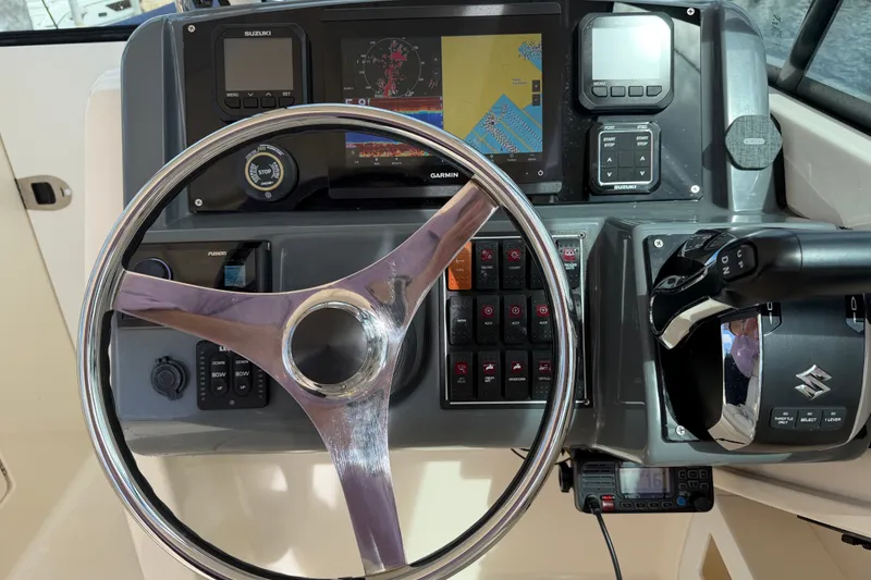 Slide: The Image of Dashboard of a 2013 Pursuit DC 265 Dual Console boat with steering wheel and controls. - 9