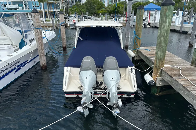 Slide: The Image of 2013 Pursuit DC 265 Dual Console boat docked with twin outboard engines. - 20