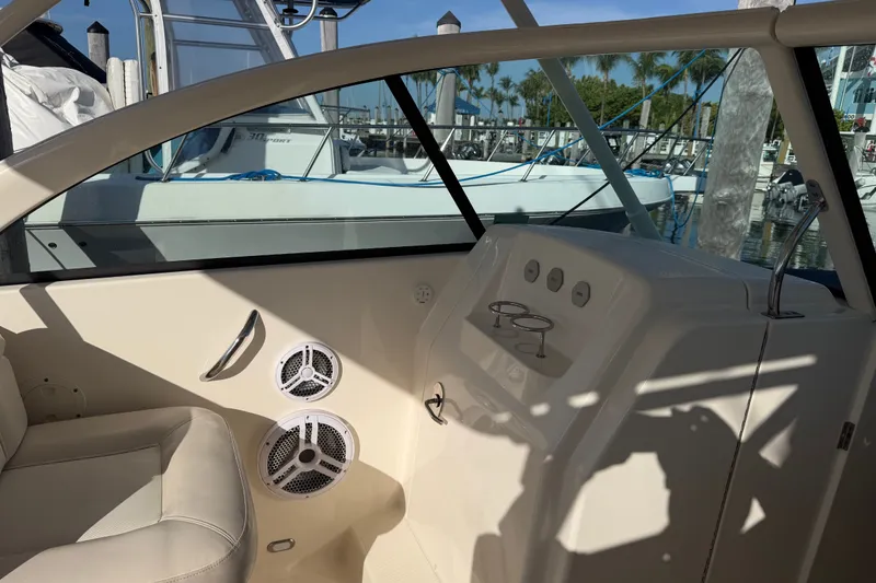 Slide: The Image of Interior of a 2013 Pursuit DC 265 Dual Console boat with seating and control panel. - 14
