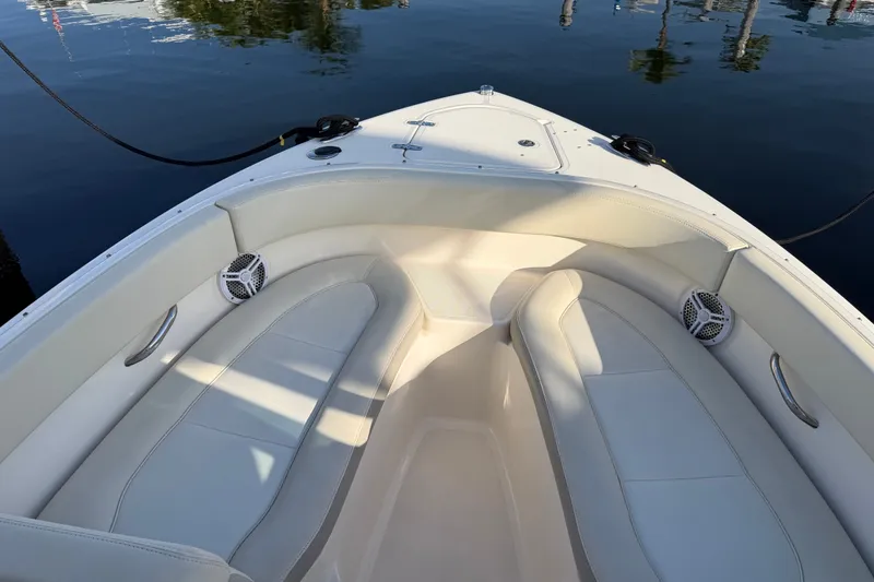 Slide: The Image of 2013 Pursuit DC 265 Dual Console boat interior with cushioned seating and speakers. - 18