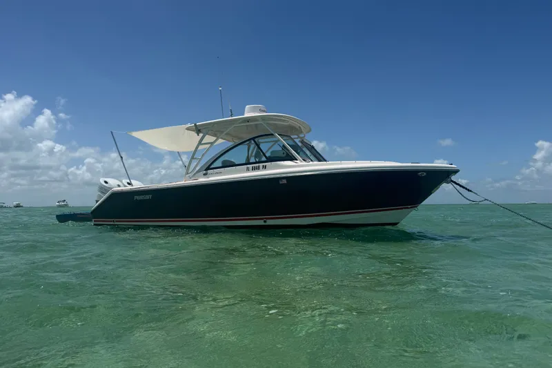 Slide: The Image of 2013 Pursuit DC 265 Dual Console boat anchored in clear turquoise water under a blue sky. - 22