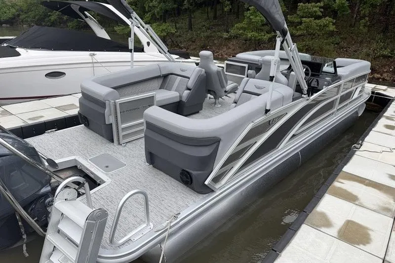 Slide: The Image of 2025 Bennington 24 MFB pontoon boat docked, featuring sleek gray seating and modern design. - 4