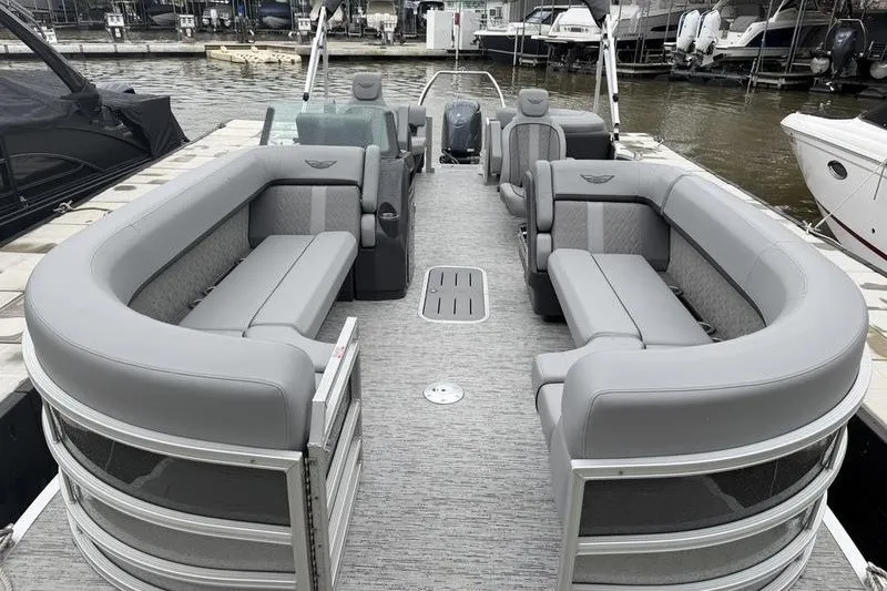 Slide: The Image of 2025 Bennington 24 MFB pontoon boat with spacious seating and modern design at a marina. - 2
