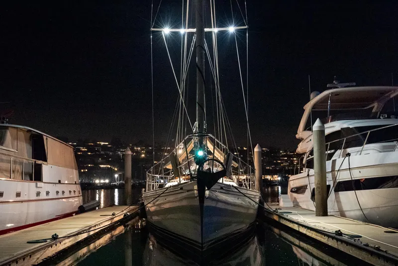 Slide: The Image of 2011 Hylas 56 yacht docked at night between two boats. - 32