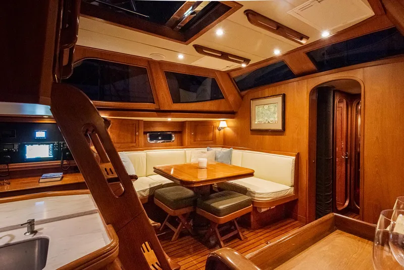 Slide: The Image of Luxurious interior of 2011 Hylas 56 yacht with wooden dining area and seating. - 21