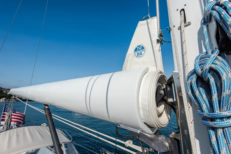 Slide: The Image of Sailboat rigging on a 2011 Hylas 56, featuring neatly coiled sails and blue ropes. - 13