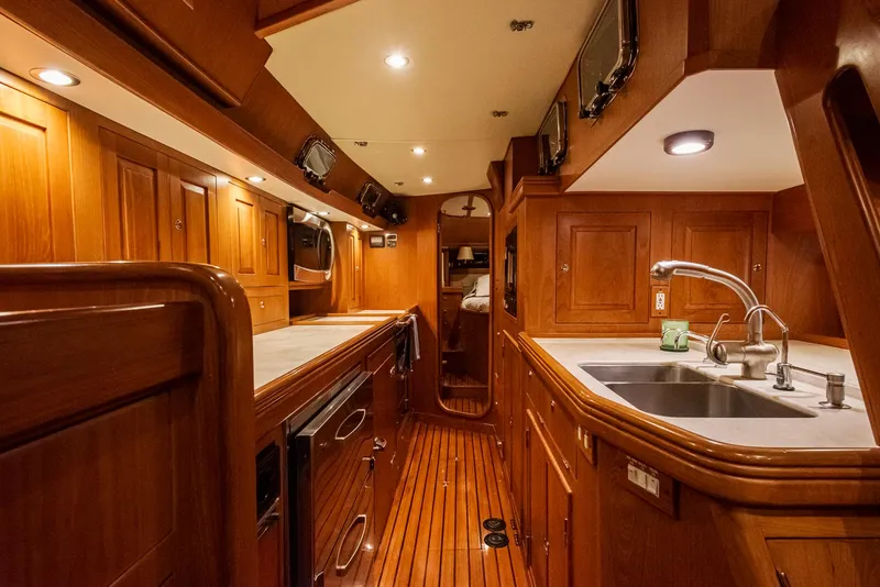 Slide: The Image of Luxurious 2011 Hylas 56 yacht interior with wooden cabinetry and modern kitchen amenities. - 24