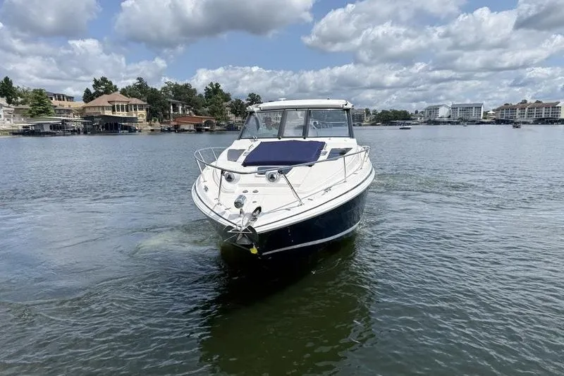 Slide: The Image of 2019 Regal 35 Sport Coupe on a serene lake with cloudy sky backdrop. - 2