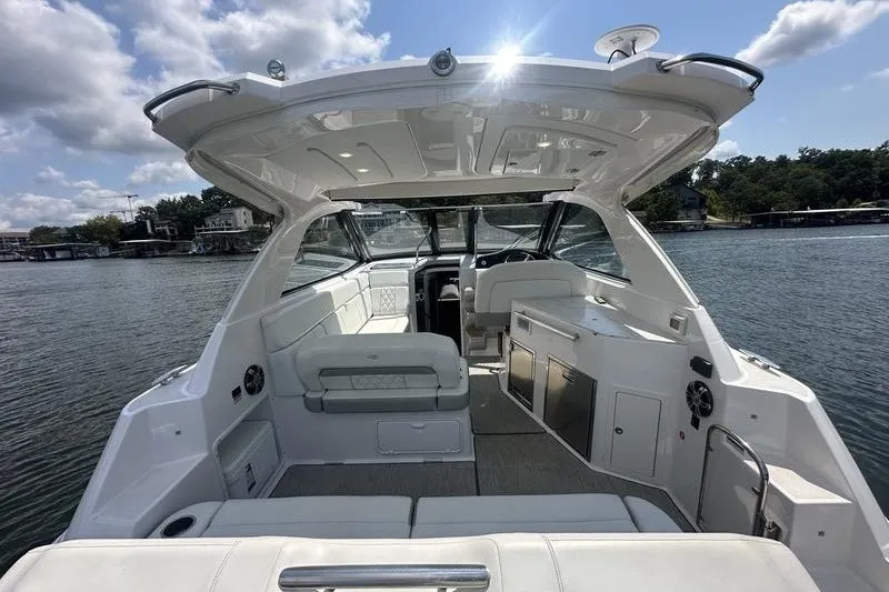 Slide: The Image of 2019 Regal 35 Sport Coupe boat interior with seating and kitchenette on a sunny day. - 6